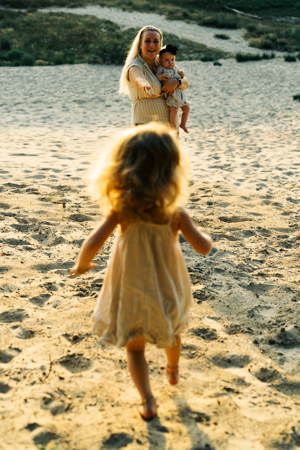 Een kind rent door het zand naar haar familie