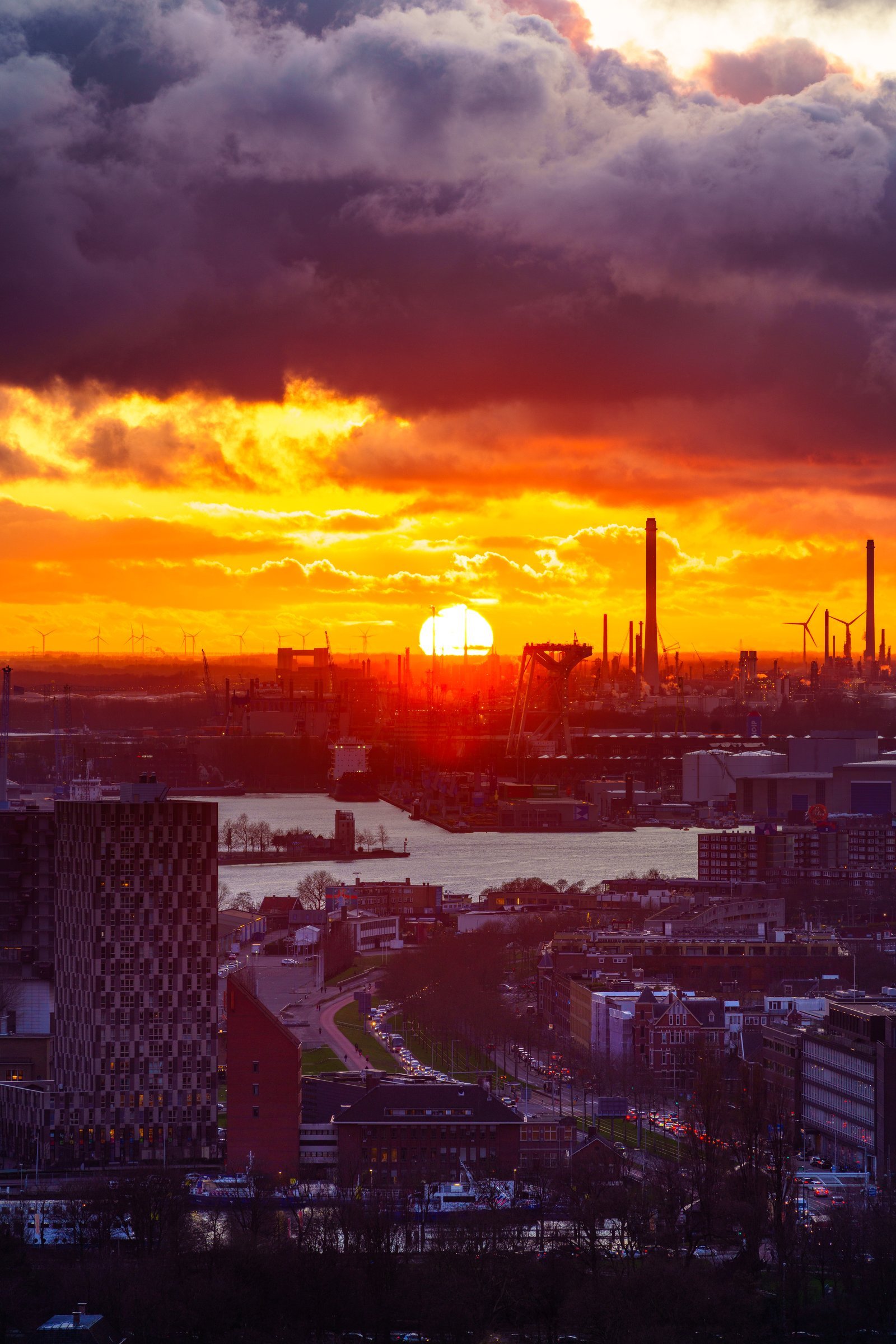 Roodoranje zonsondergang boven een havengebied