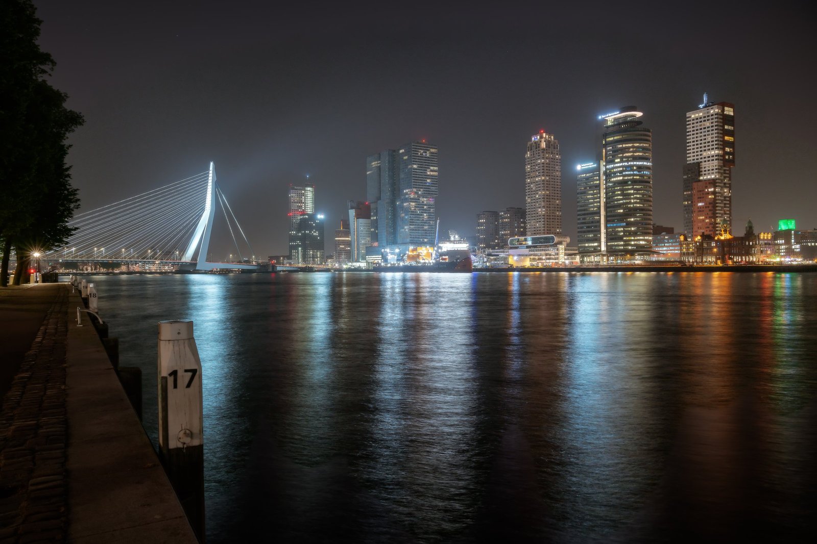 Nachtelijk uitzicht op de Wilhelminapier en haar weerspiegeling in de Maas